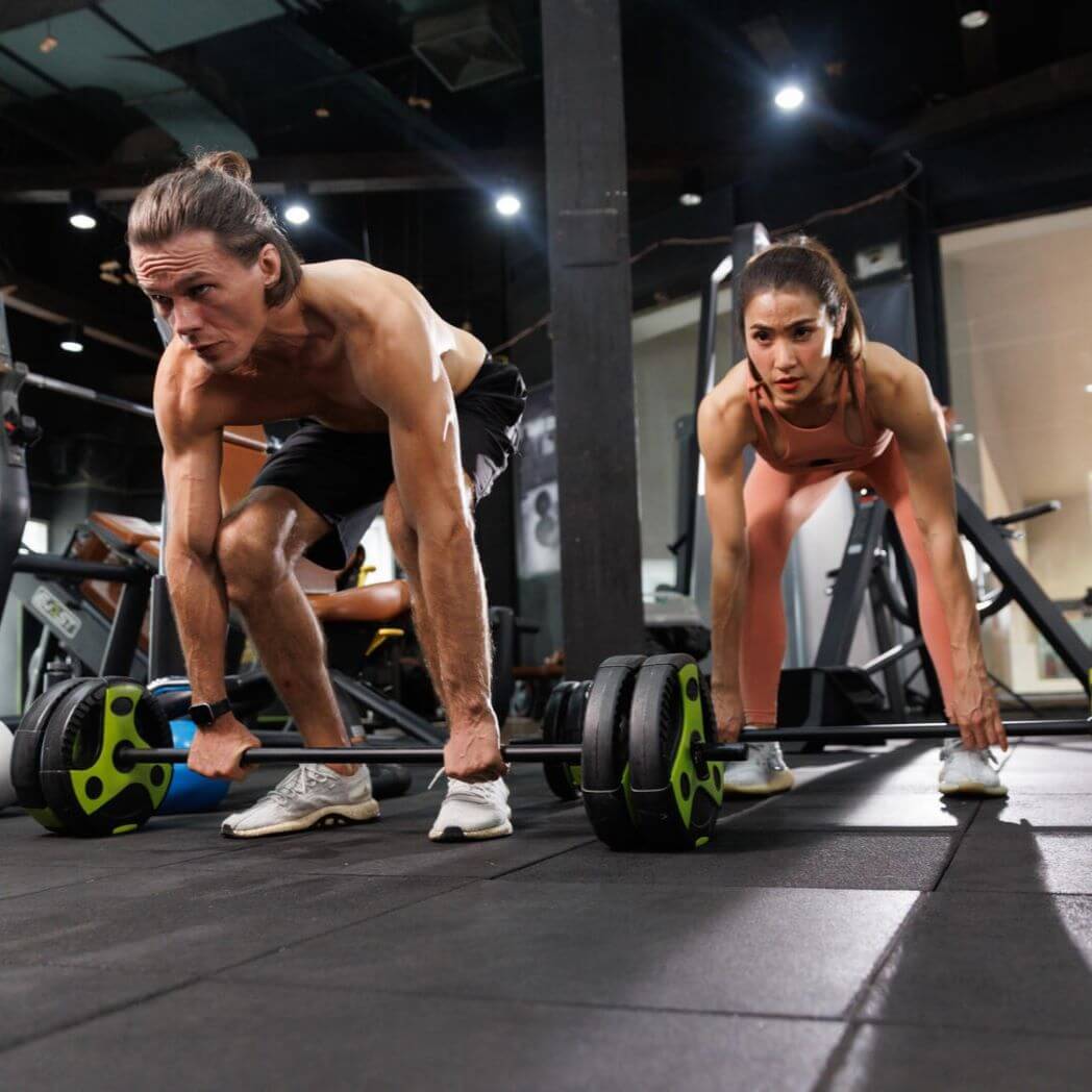 A couple lift weights in a gym