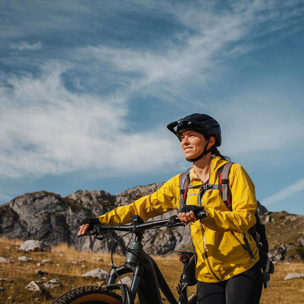 A woman takes a break from riding her bike through the mountains.